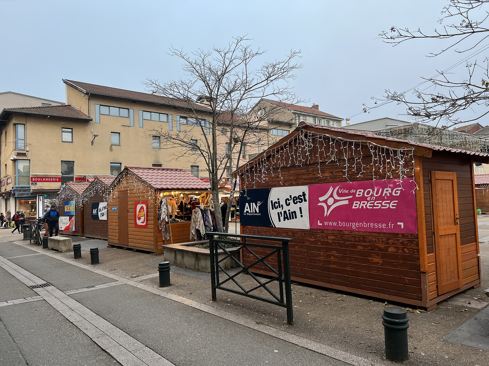 Chalets d'un marché de Noël en fin de journée, guirlandes allumées